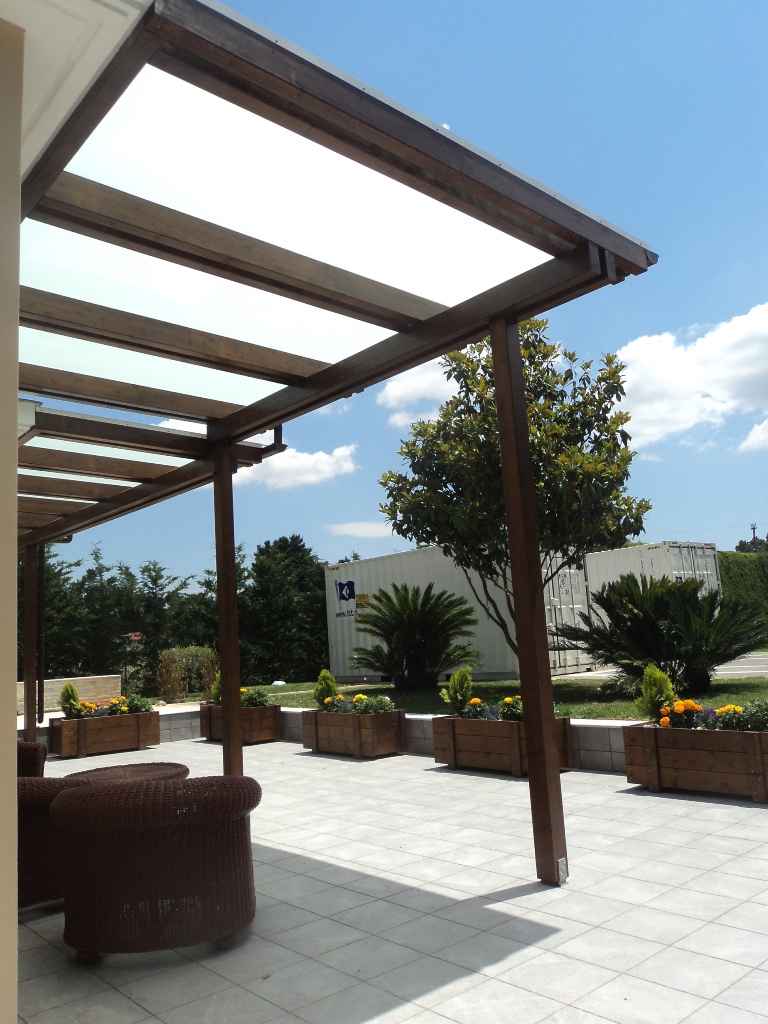 Πέργκολα με ξύλο και τζάμι, σε παραδοσιακό στυλ με σύνθετη ξυλεία και τρίπλεξ τζάμι